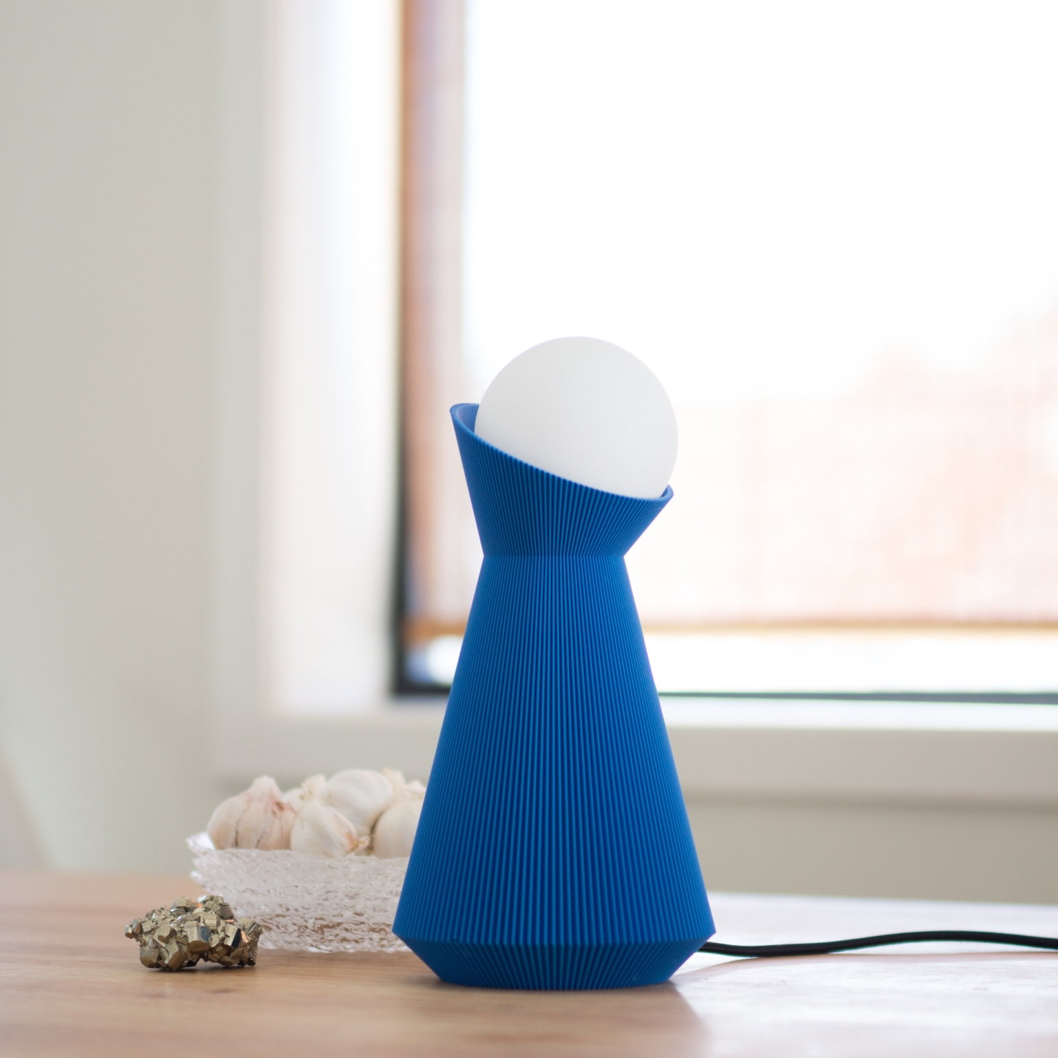 Sera table lamp in denim blue on a windowsill
